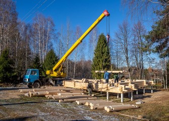 construction of wooden houses made of logs with a crane