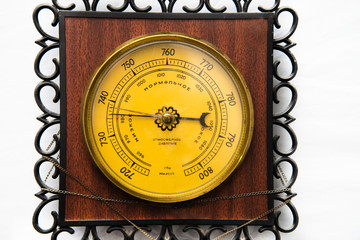 The vintage wooden barometer isolated , household barometer . Inscriptions on the surface, translated from Russian: Atmosphere pressure, low, normal, high.