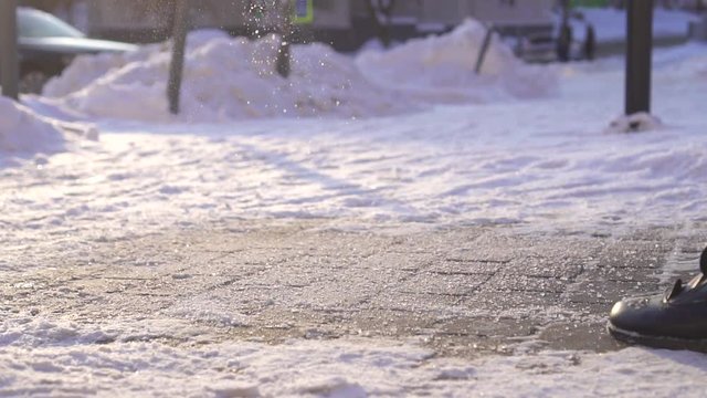 Sprinkle de-icing reagent to the ice in winter slow mo