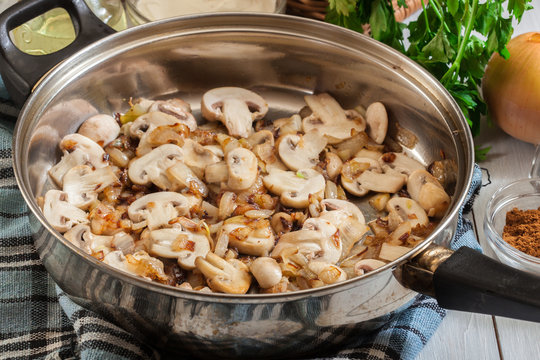 Mushrooms and onion on a fried pan