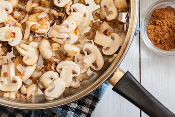 Mushrooms and onion on a fried pan