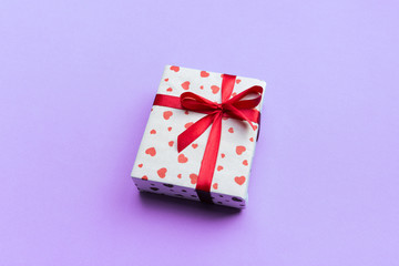 Background with gift box and hearts on purple Background. Top view with copy space for text