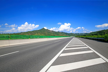 Fototapeta premium Highway, under the background of blue sky and white clouds