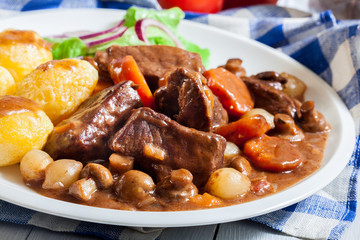 Beef Bourguignon stew served with baked potatoes
