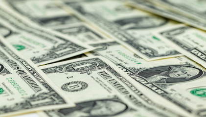 One-dollar bills are on the table in an even layer