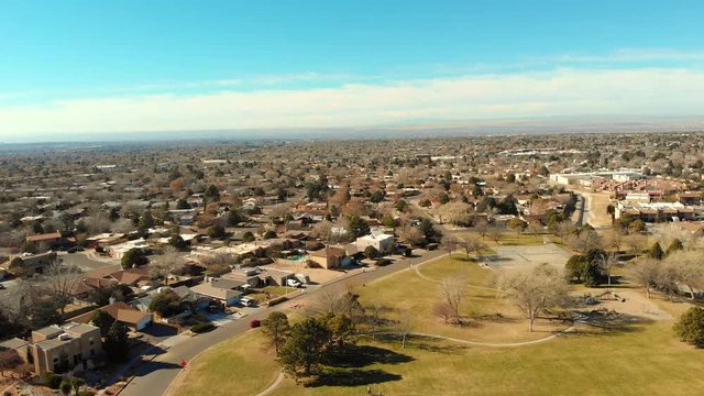 Aerial shot of a drone flying over a park to show the city.