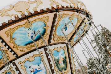 Carousel in winter snowy park. Dynamic photo.