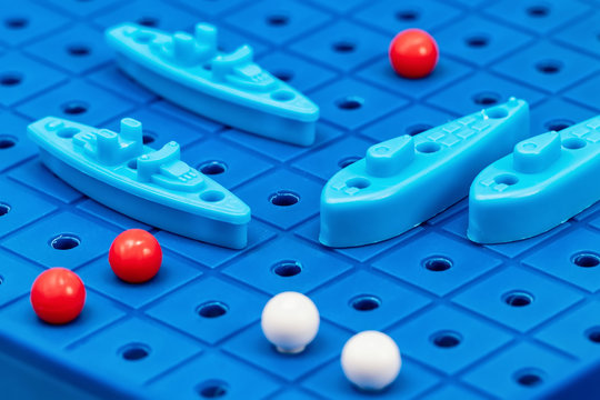 Toy war ships and submarine are placed on the blue  playing Board