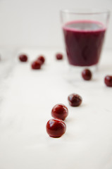 Glass with cherry juice and berries around of it