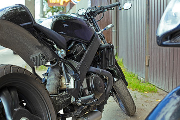 Cropped close up shot of beautiful and custom made motorcycle parked on the street