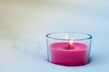 a red candle stands in the snow