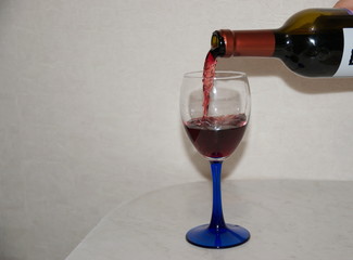 Red wine is poured from a bottle into a glass.