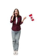 Naklejka premium excited woman holding canadian flag and talking on smartphone isolated on white