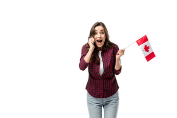 surprised woman holding canadian flag and talking on smartphone isolated on white