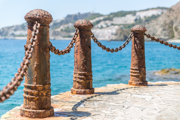Obraz premium Metal bollards and chains to make a barrier on a beautiful beach in southern Spain, Almunecar
