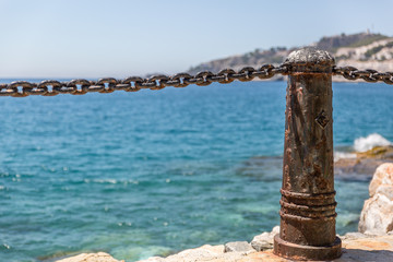 Fototapeta na wymiar Metal bollards and chains to make a barrier on a beautiful beach in southern Spain, Almunecar