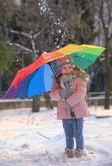 Little girl under umbrella in winter