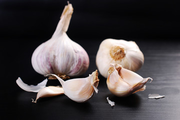 fresh garlics with cloves on black background