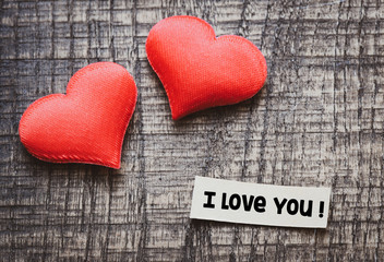 I love you text on a wooden background with a red heart.