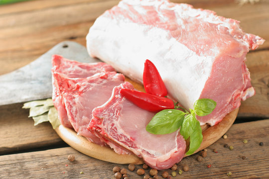 Schab z kością. Świeże mięso na drewnianej desce w kompozycje z warzywami