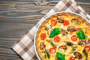 Baked homemade quiche pie in ceramic baking form