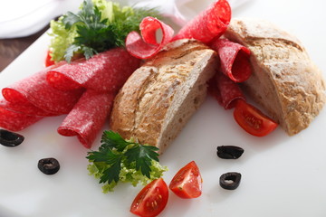 Salami i  pieczywo. Kompozycja smakowitych wędlin na desce