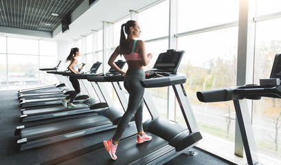 Woman running on treadmill at panoramic window
