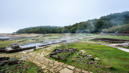 Natural Roman baths outdoors with hot steam and thermal water.