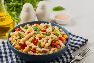 Italian fusilli pasta in a salad with ham and vegetables.
