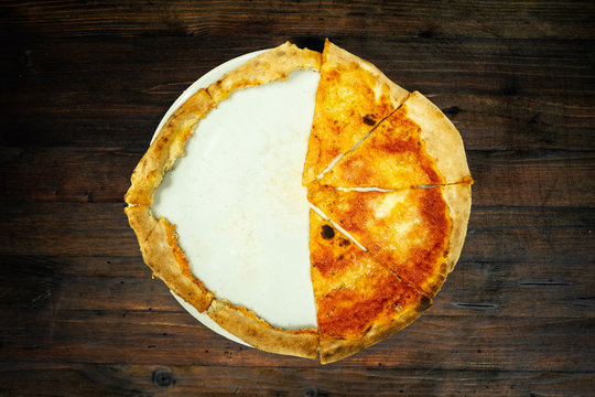 Half Pizza Sliced On A Plate Over A Wooden Background