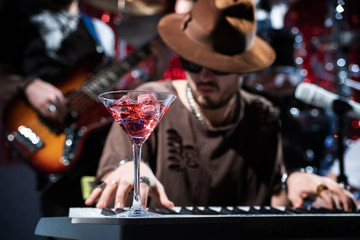 A glass of alcohol and musicians