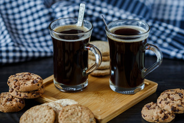 Two cups of coffee and chocolate and oatmeal cookies