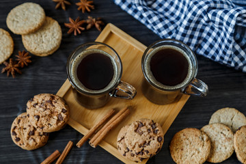 Two cups of coffee and chocolate and oatmeal cookies