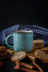 Cup of tea and various cookies on dark wooden background