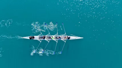 Foto op Canvas Aerial drone bird's eye view of sport canoe operated by team of young men in open sea © aerial-drone