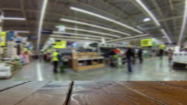 A crowd of buyers walk around the big supermarket of building and finishing materials. Defocused image.