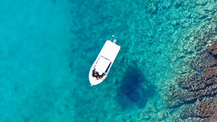 Fototapeta premium Aerial top view of boat in tropical sapphire clear waters