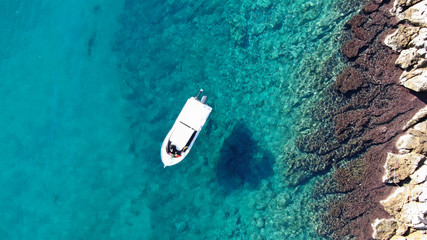 Aerial top view of boat in tropical sapphire clear waters