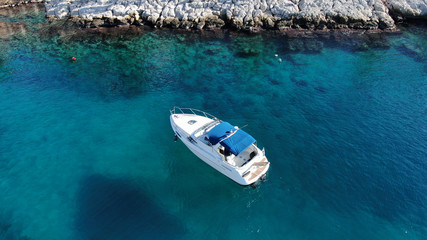 Aerial bird's eye view photo taken by drone of boat cruising in caribbean tropical beach with turquoise - sapphire waters