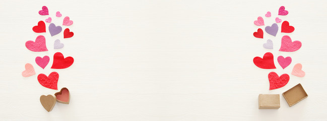 Valentine's day concept. Paper hearts over wooden white background. Flat lay.