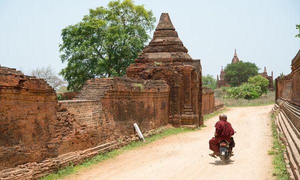 Buddhist monk riding motorcycle, Bagan, Myanmar　バイクに乗って移動する僧侶（ミャンマー・バガン）