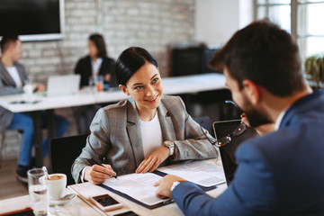 Two businesswoman make a deal and signing a contract