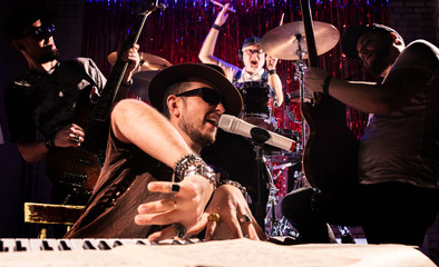 The musician plays the synthesizer and sings . Musical Quartet.