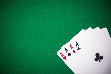 Four aces folded on green casino table, copy space