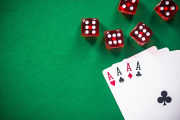 Four aces poker cards and red dices on casino table