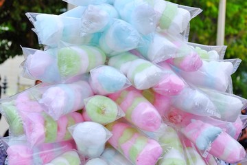 Cotton candy in packing bag selling in the open market in Thailand with blur people and trees background 