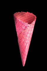 Pink empty wafer cone on dark background