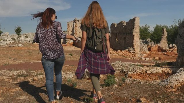 Two young girls exploring ancient city Lyrboton, Turkey