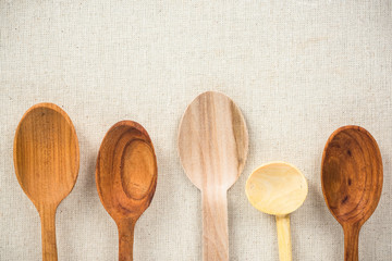 Empty wooden rustic spoons on kitchen cloth