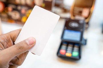 Hand paying with contactless credit card with NFC technology.